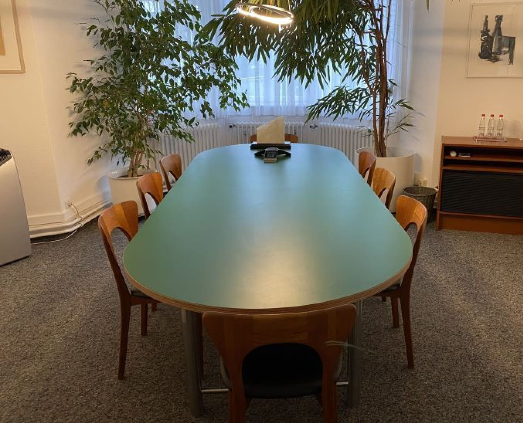 Besprechungsraum der Kanzlei mit grünem Konferenztisch